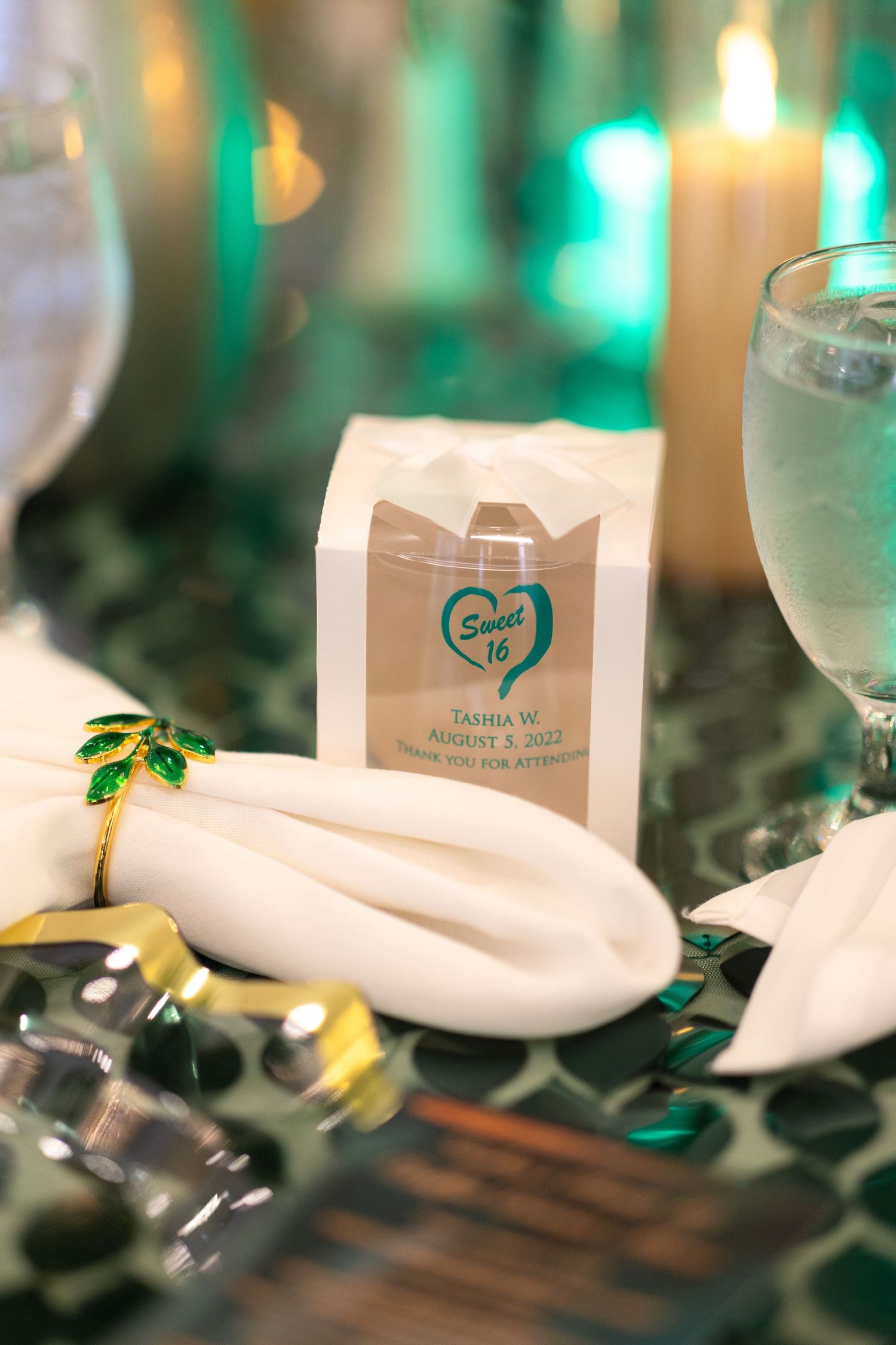 Wedding reception table setting with personalized name cards and green ambient lighting.