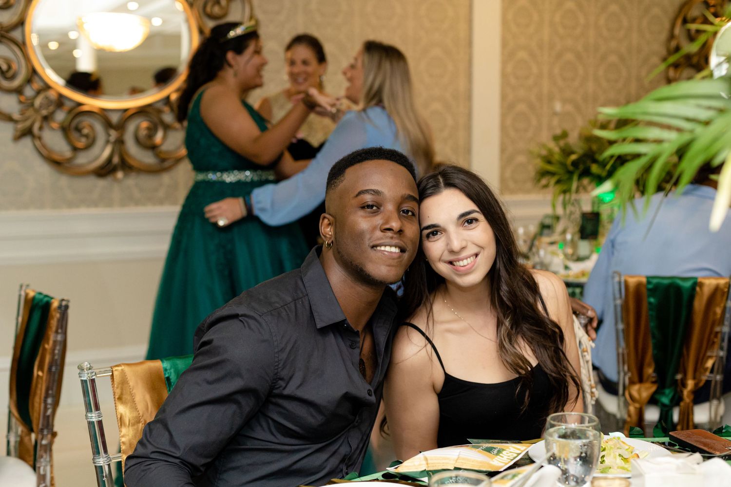 Wedding reception guests share joyful moments at tables decorated with elegant centerpieces.
