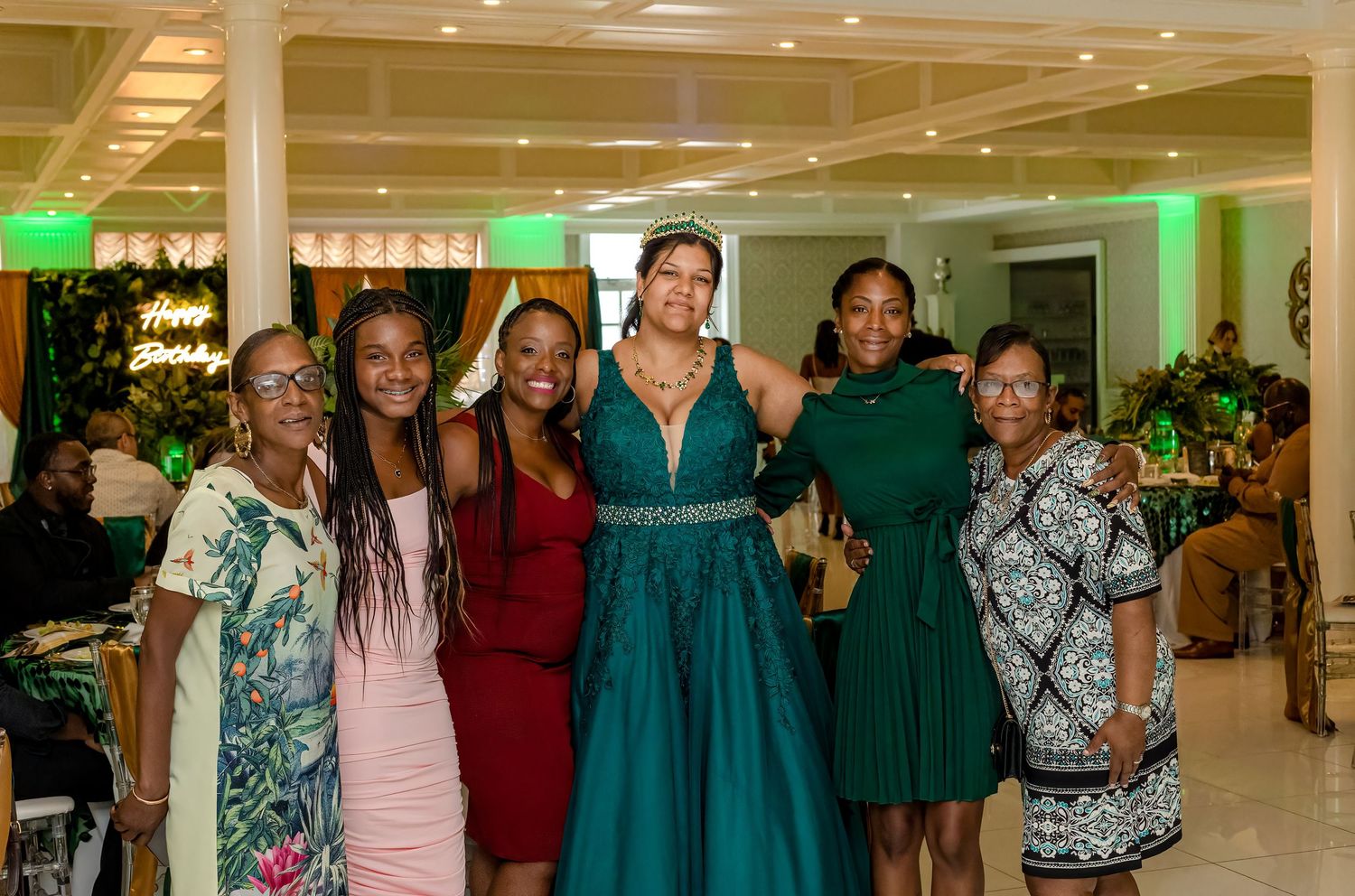 Large group photo of event attendees in formal attire standing together in elegant venue.