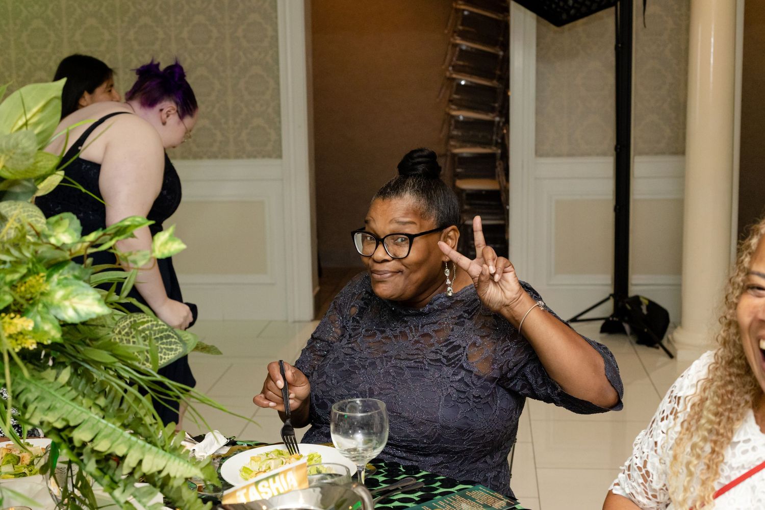 Friends gathered at formal dinner event with decorative interior and ambient lighting.