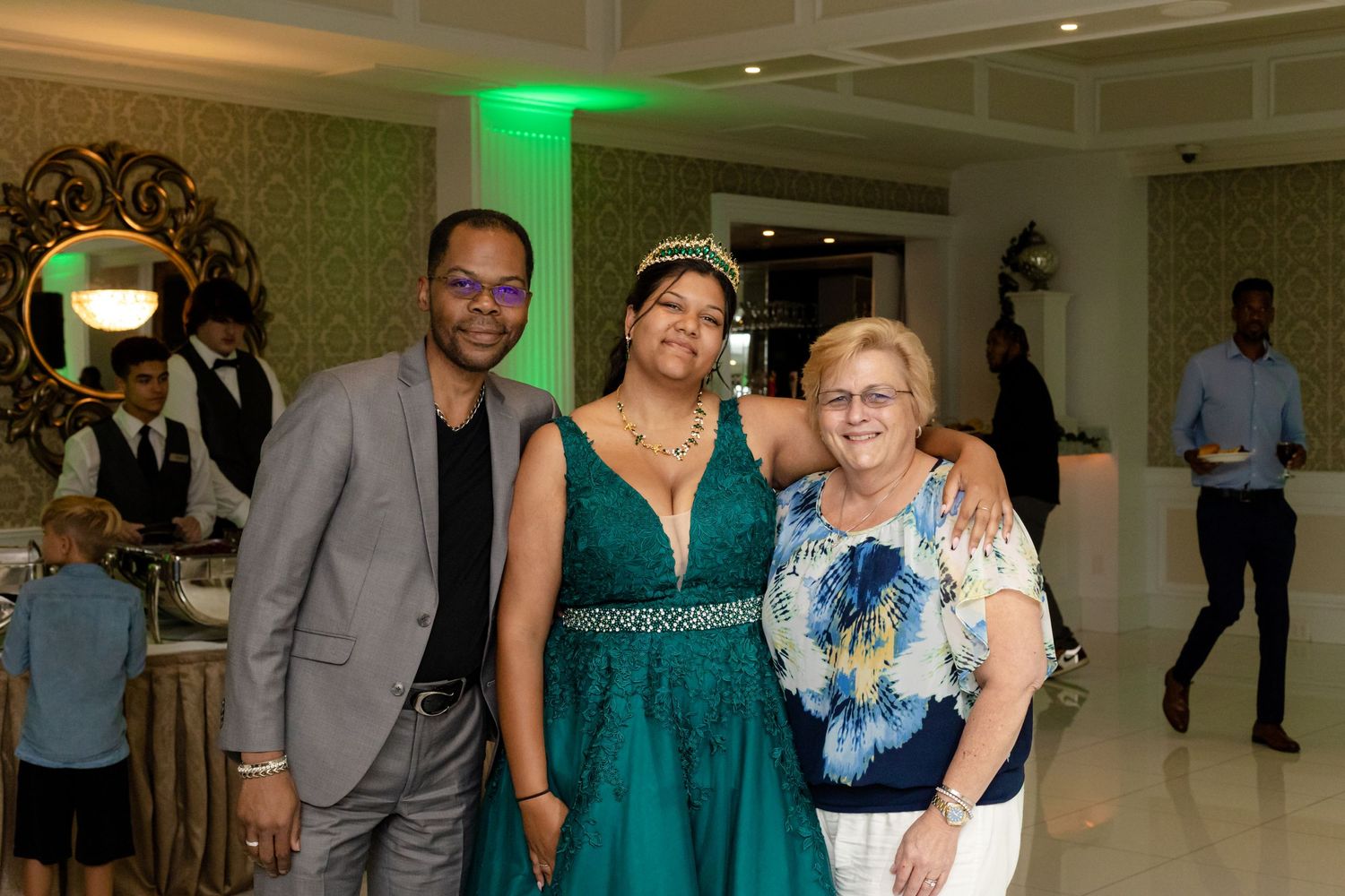 Event guests mingling and posing for photos in formal venue with ornate decor.