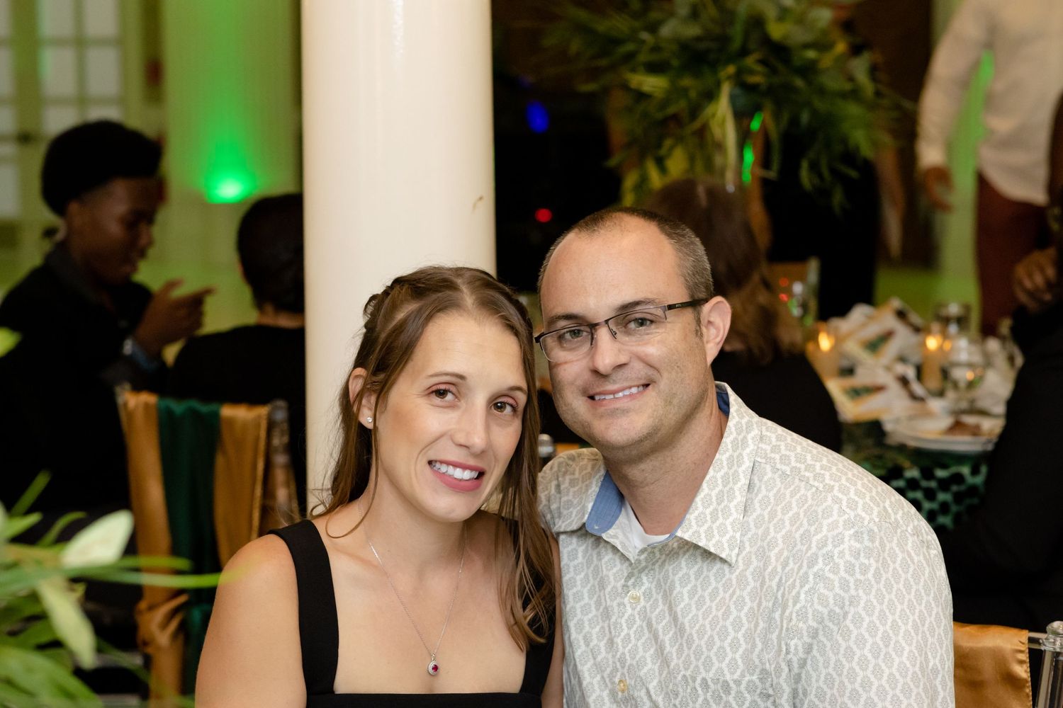 Couples and guests enjoying a social event in an elegantly lit indoor venue.