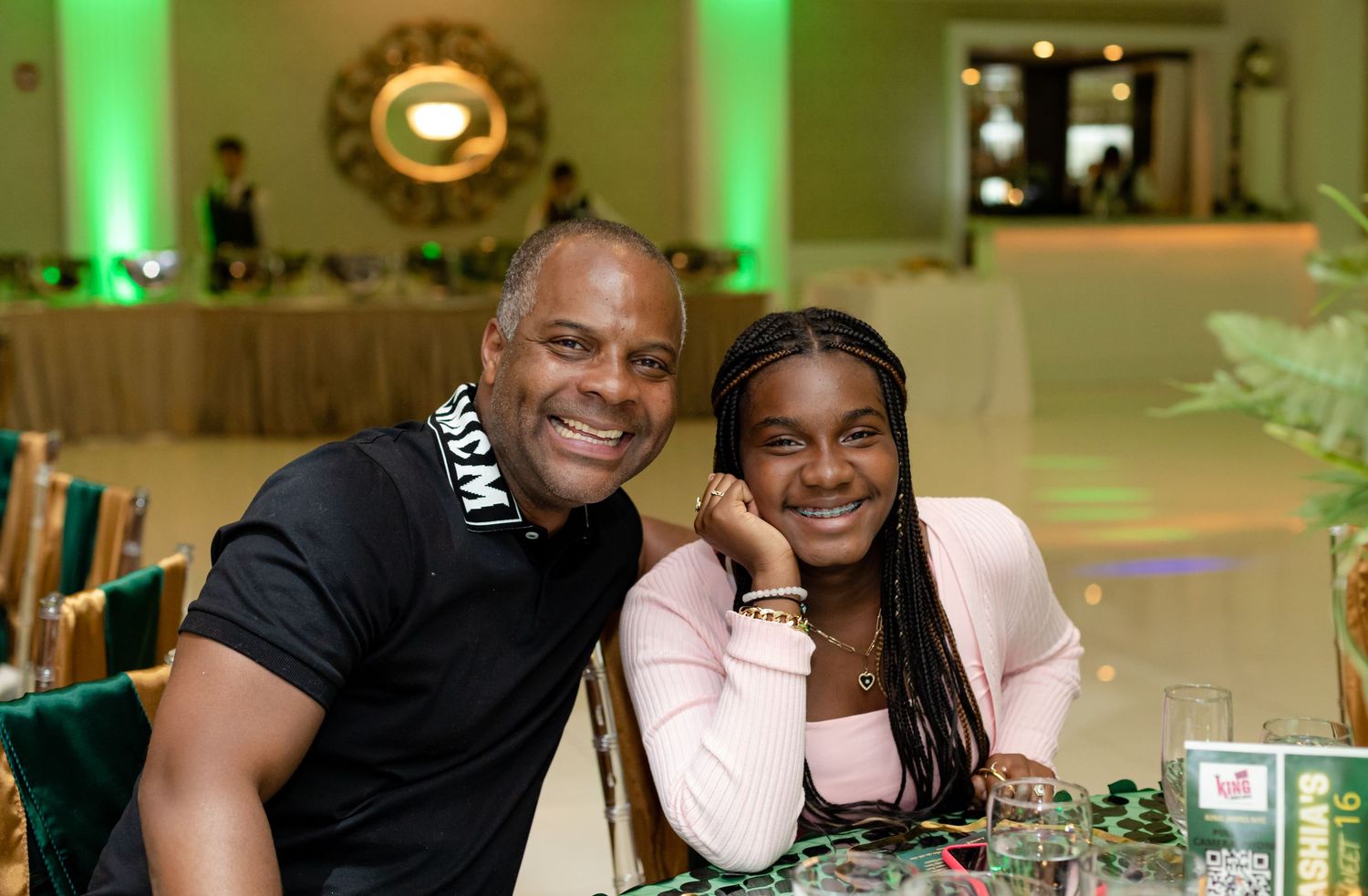 Happy guests enjoying themselves at an evening reception with green ambient lighting.