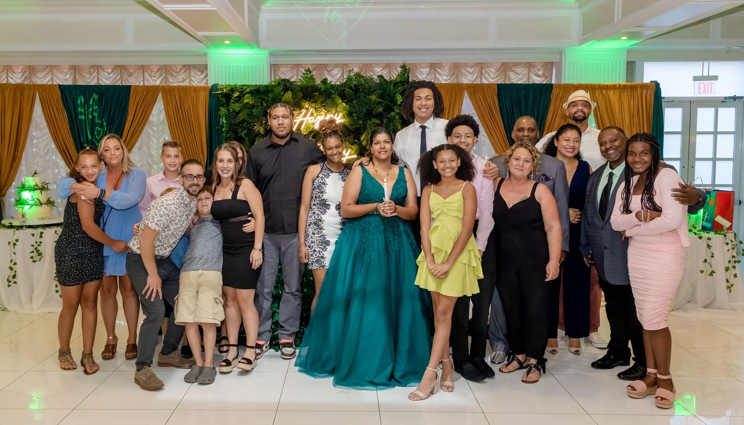 Wide shot of celebration guests posing together in formal attire.