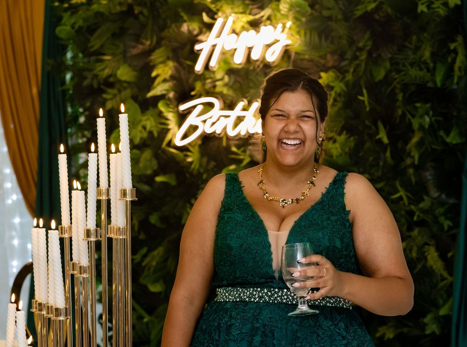 Guests enjoying a festive celebration with champagne and neon lighting.