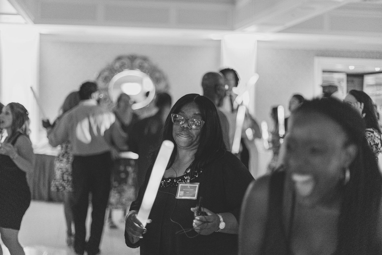 Candid moments captured at a wedding reception with guests mingling in a bright ballroom space.
