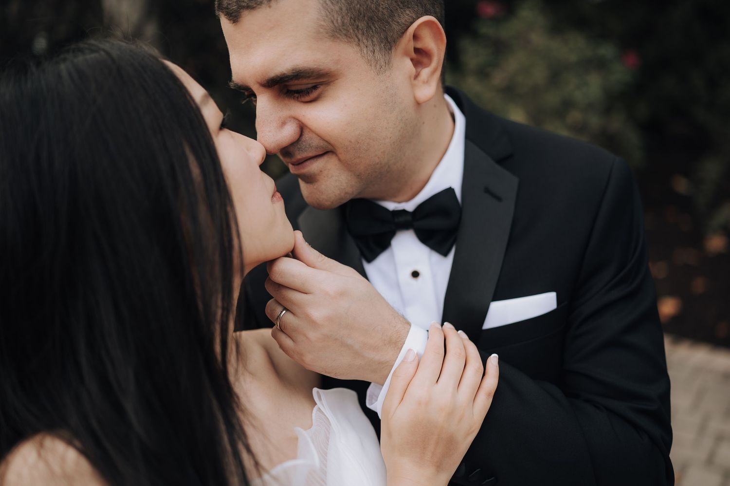Intimate close-up of newlyweds sharing a romantic moment during their wedding photoshoot.