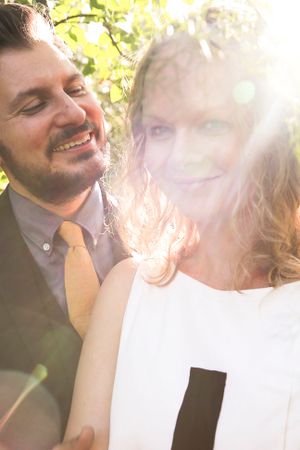 A romantic sunlit moment captured through leaves and natural lens flare.