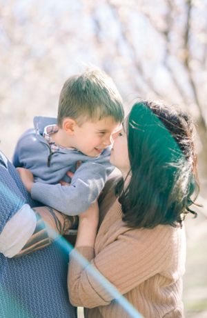 A tender family moment captured in soft focus among blooming trees.