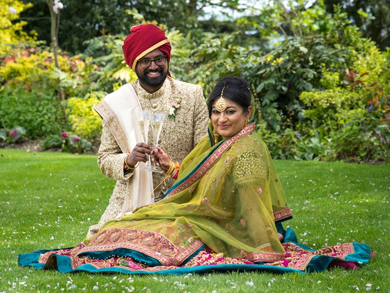 Indian couple toast wedding in traditional outfits Harrow School, Hertfordshire. By Abigail's Studio