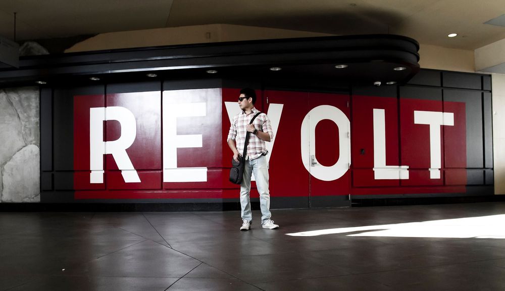 Bold red REVOLT text display in a dark underground space.