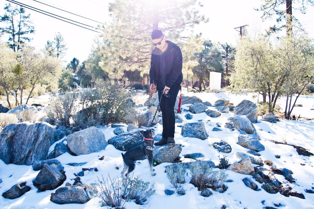Person standing among snow-covered rocks in winter landscape.