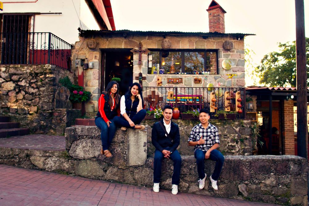 Group enjoying a relaxed moment outside rustic stone building with vintage charm.