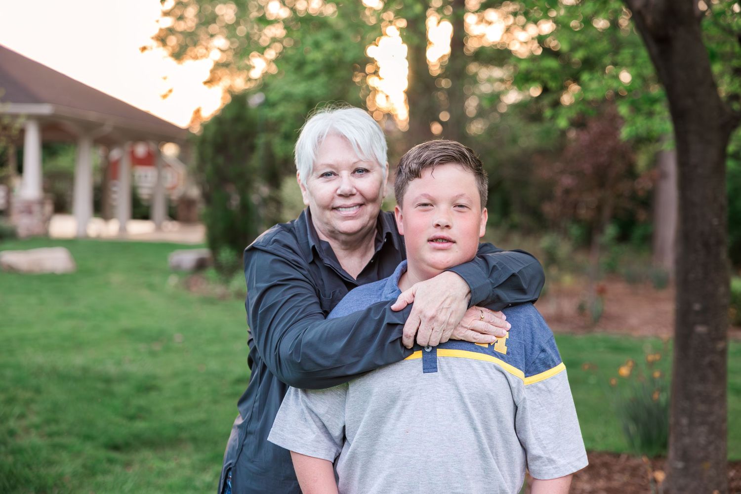 An affectionate outdoor portrait of two people against a sunset backdrop.