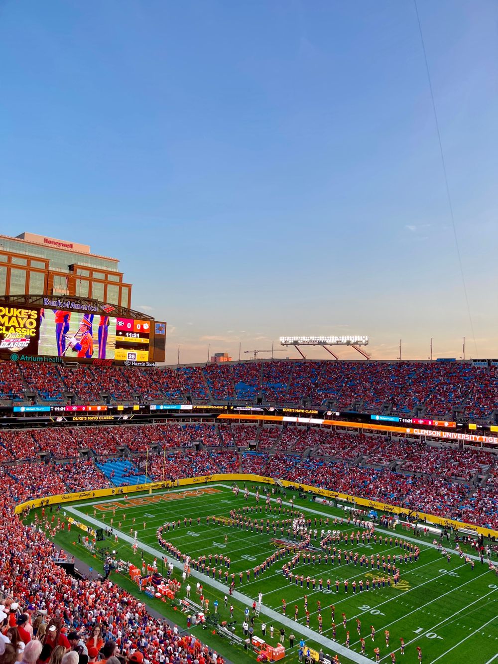 Packed football stadium during game showing field formation and crowded stands.