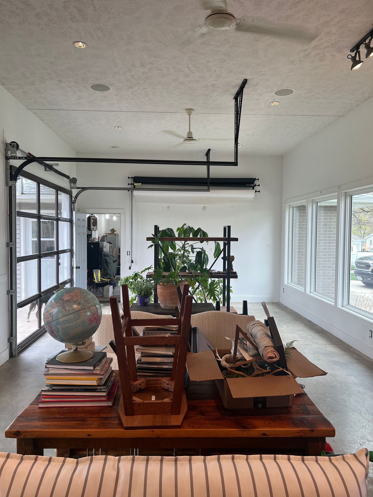 Bright room with vintage decor including globe, books and wooden furniture near glass doors.