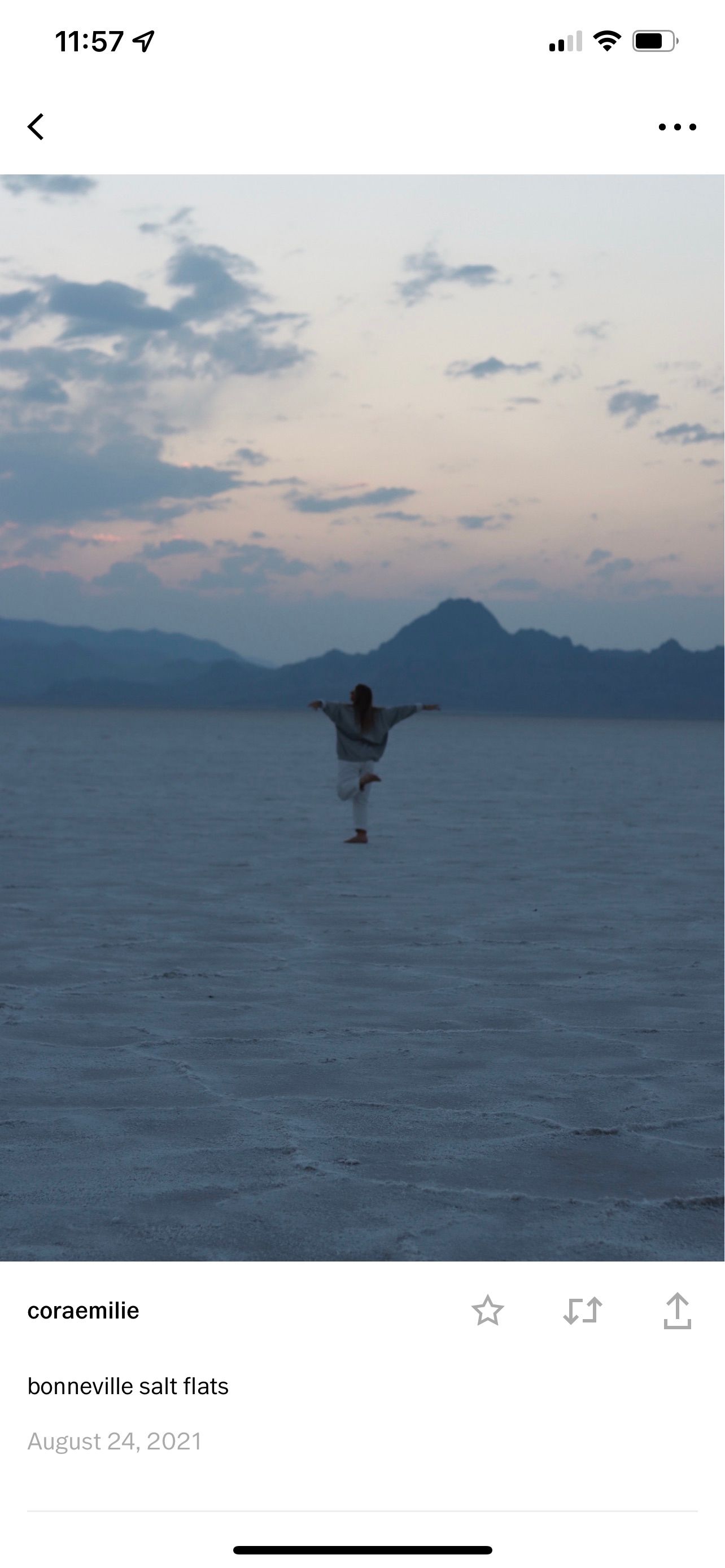 Cora Emilie Media Silhouette of person jumping at Bonneville Salt Flats during sunset with mountains in background.