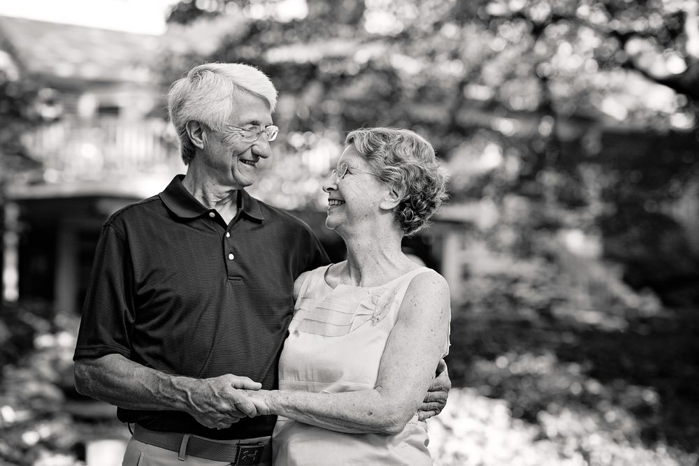Black and white portrait of elderly couple sharing tender moment outdoors.