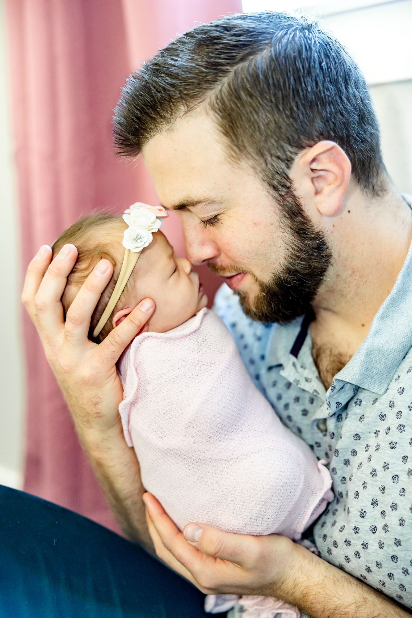 Dad touches noses with eyes closed with his new baby girl during newborn photos in Colorado Springs.