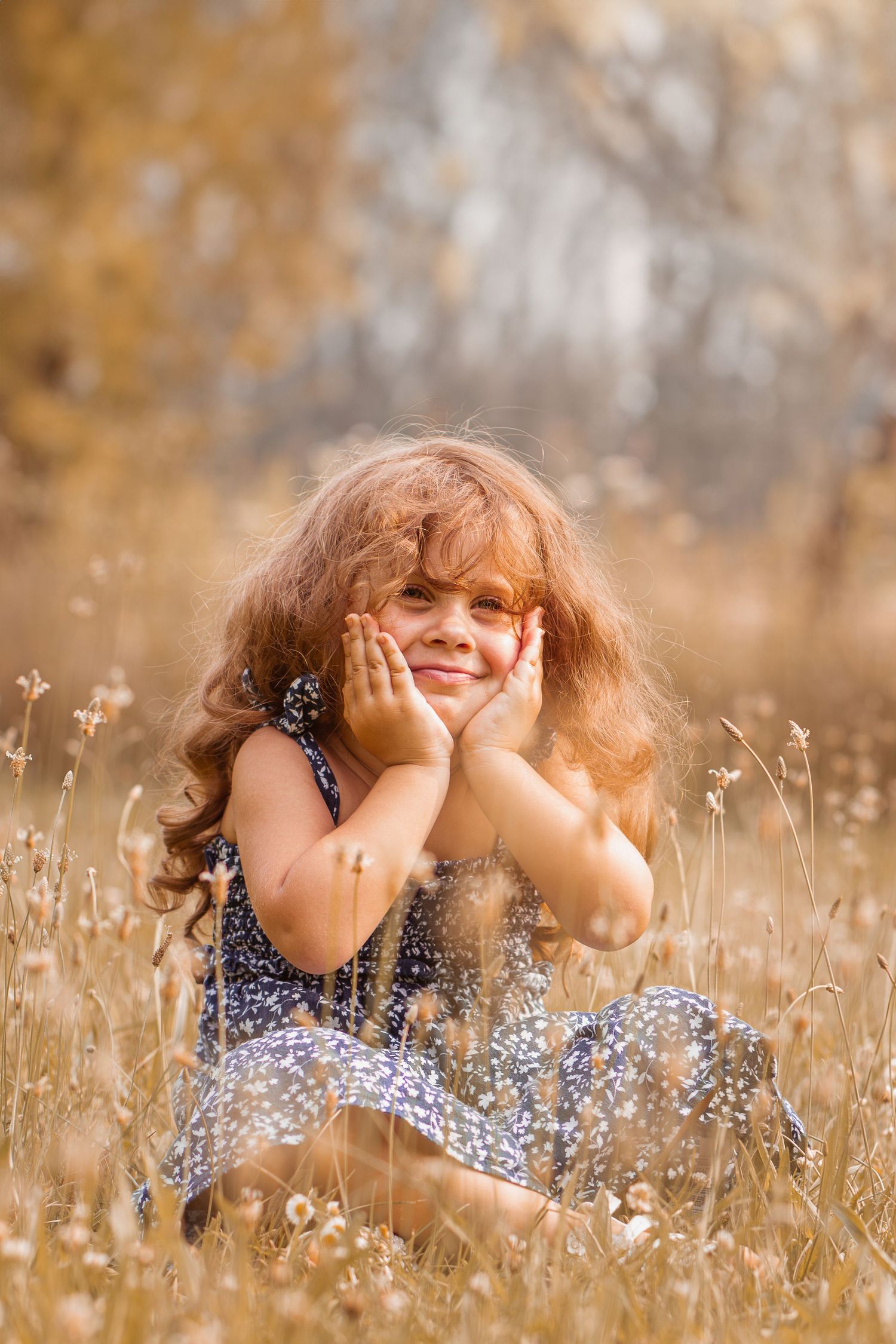 A playful moment captured in a wheat field with a blue floral dress.