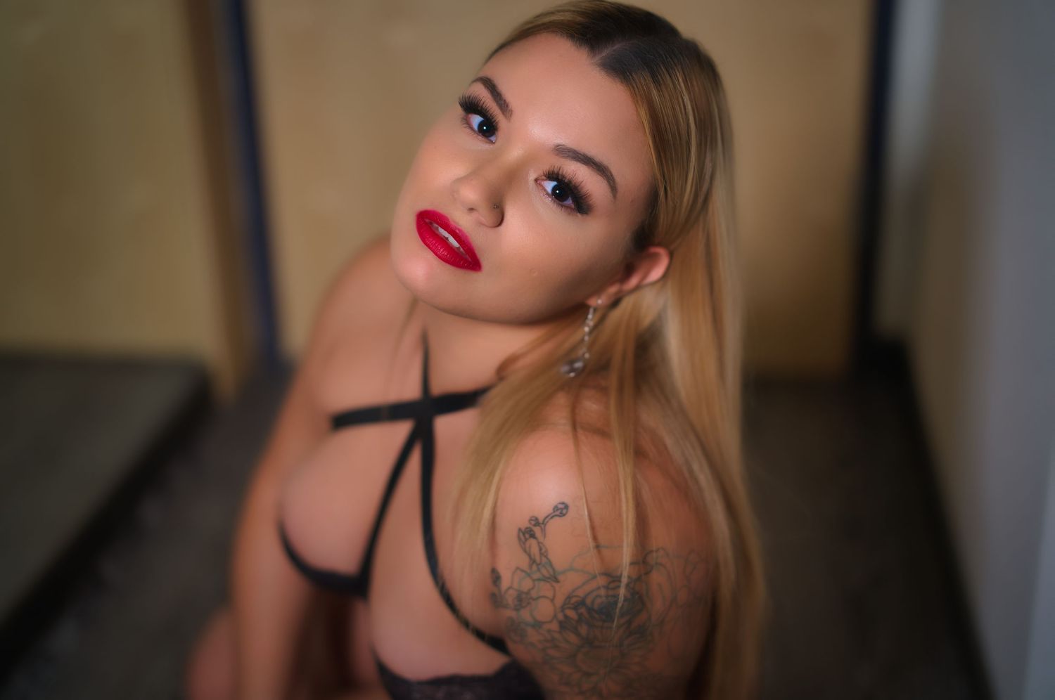 A boudoir photography session featuring intimate poses in a dimly lit hall setting.