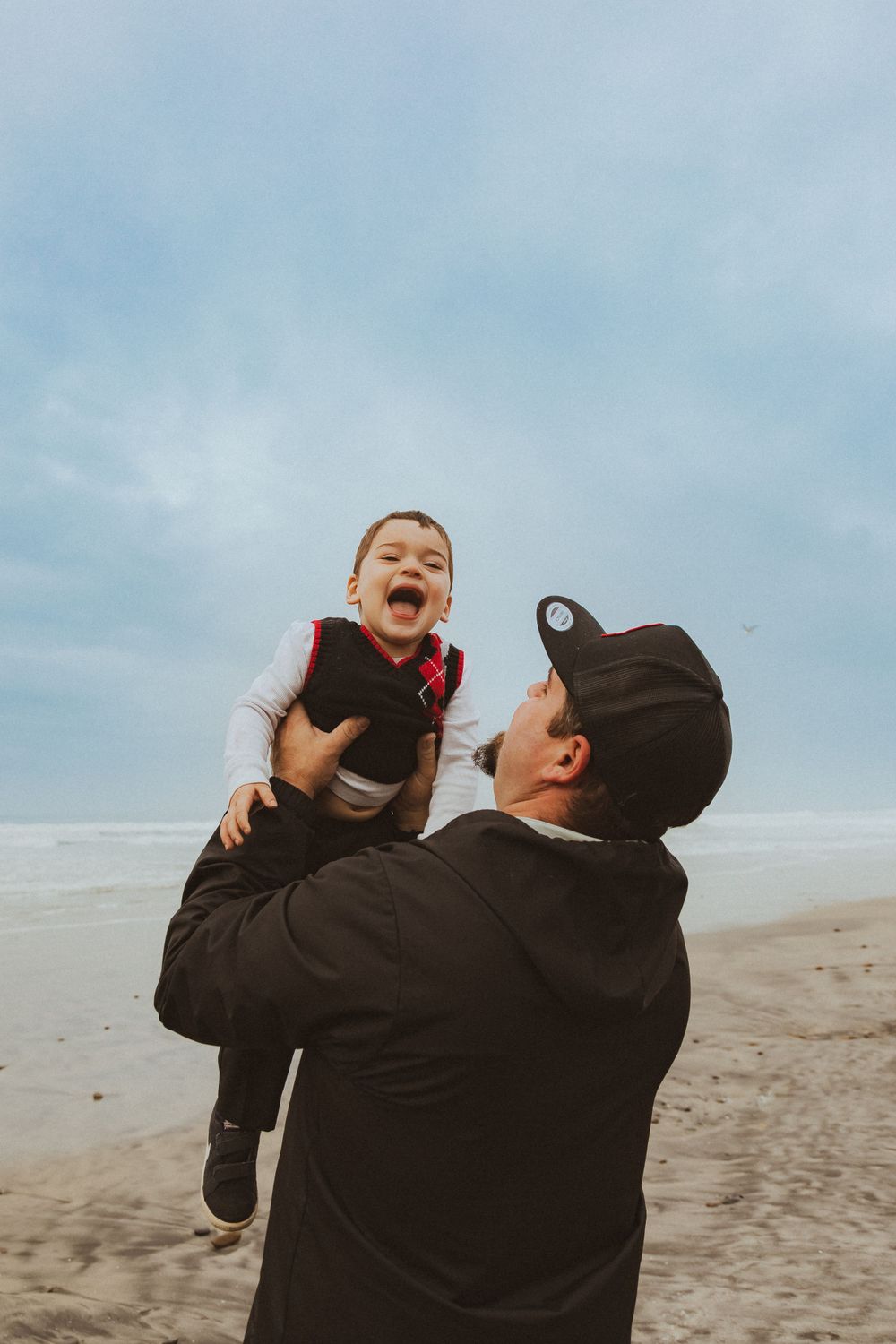 Joyful moment shared between parent and child playing on a misty beach.