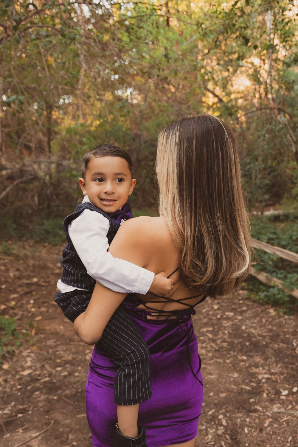 A sweet candid moment between two people on a wooded trail with autumn foliage.