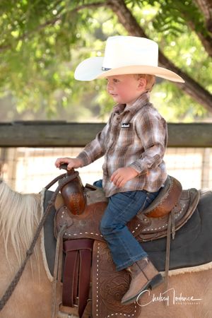 Jake celebrating his second birthday with his cowboy hat and palomino pony