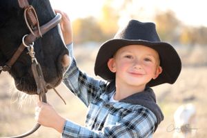 Young cowboy petting horse during birthday photoshoot in Sonoma County