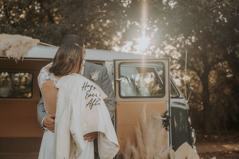Vintage car parked during golden hour wedding photoshoot with sun flare.