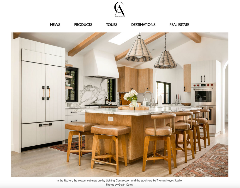 Bright modern kitchen with wooden island, white cabinetry and pendant lighting.