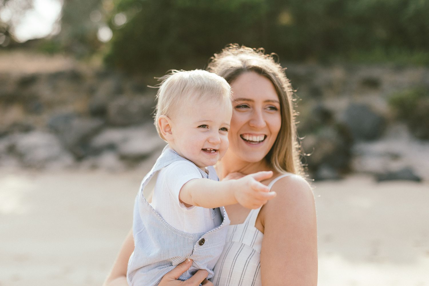 Joyful moments captured between mother and baby during beach sunset session.