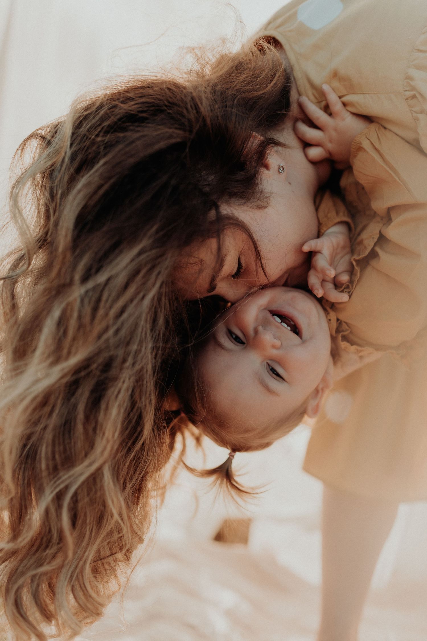 Intimate close-up portrait of loving couple with long hair in warm natural lighting.