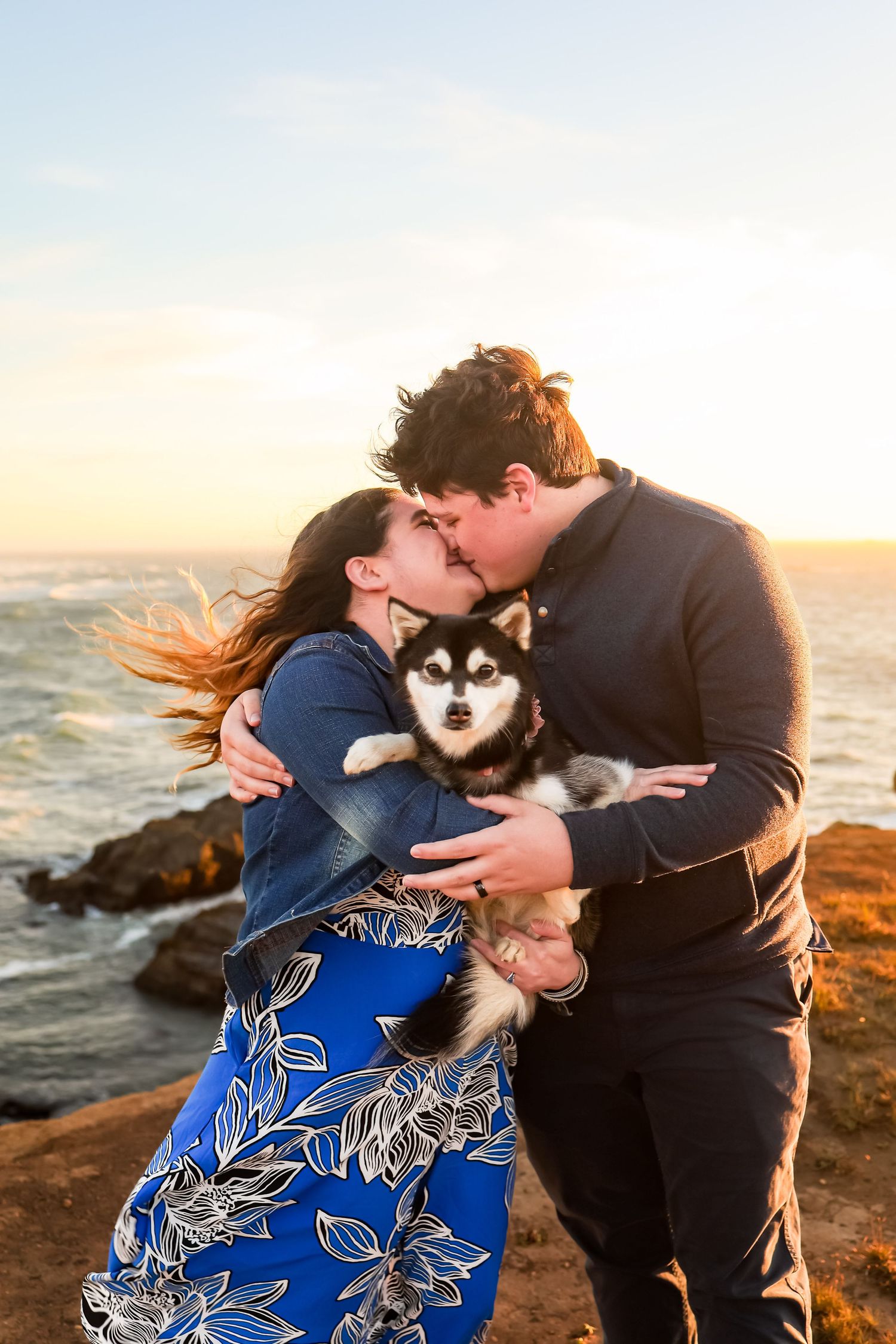 Couple getting anniversary photos done with their sweet dog along the Southern Oregon Coast at sunset