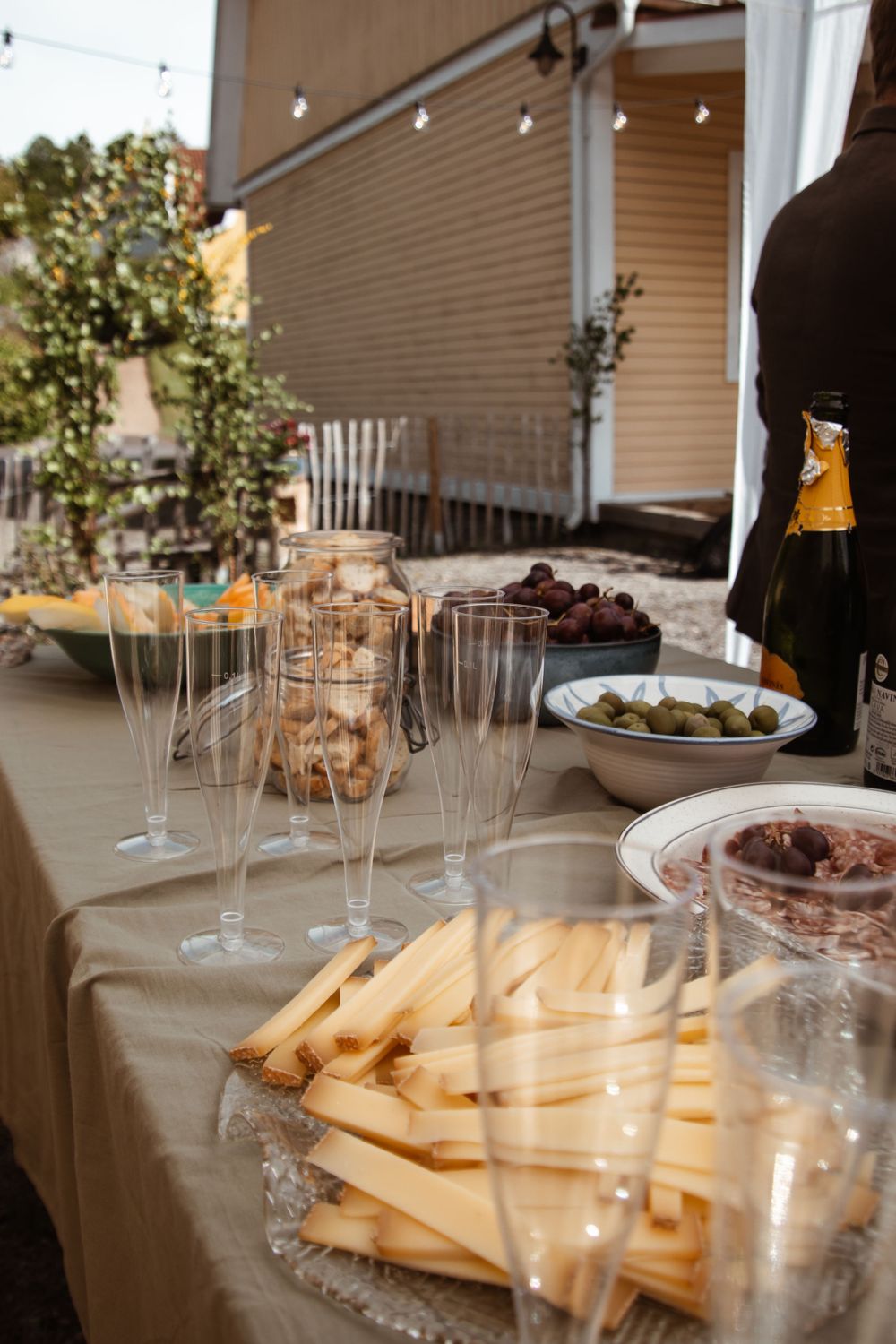A buffet table set with champagne glasses and appetizers for an outdoor event.