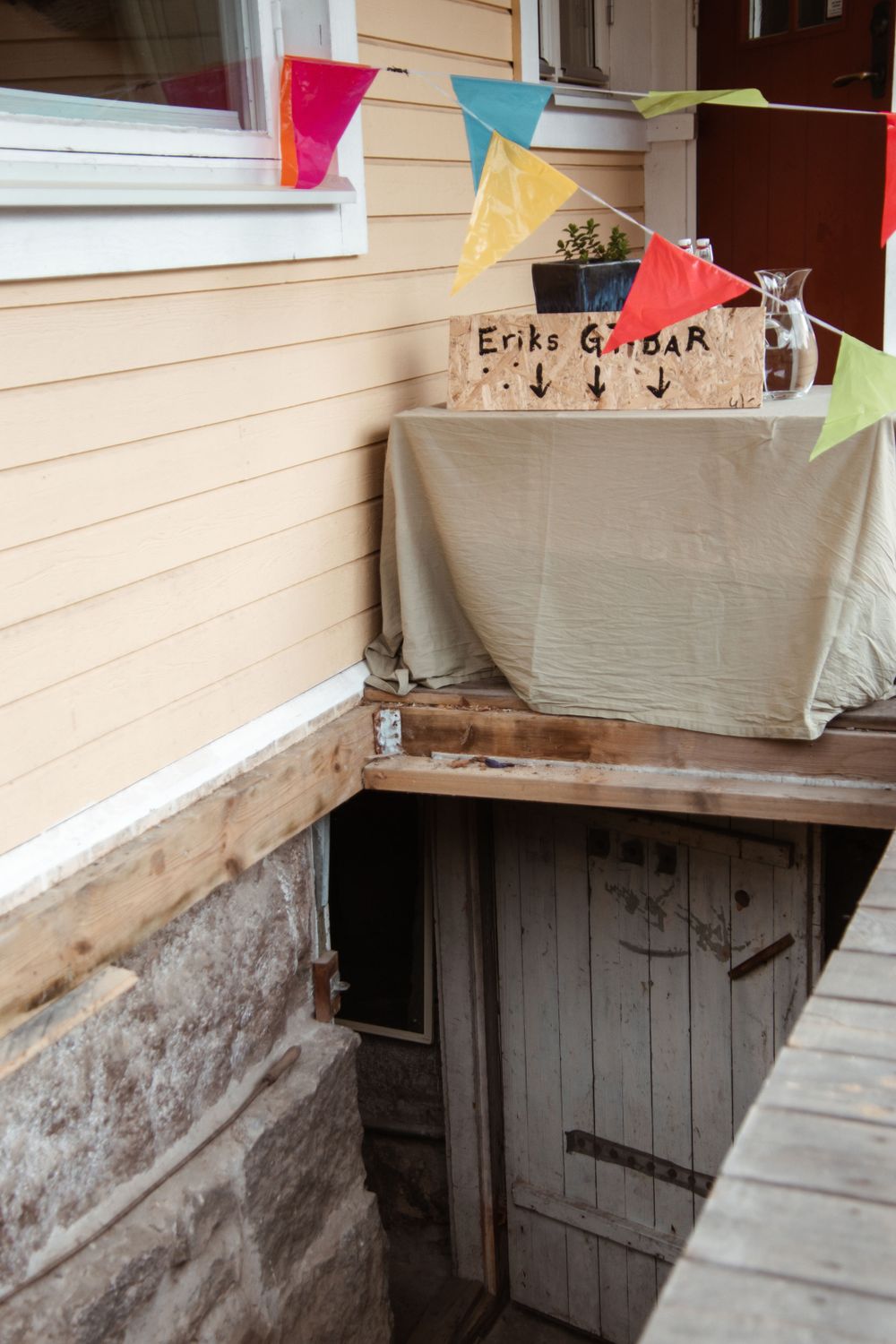 Colorful triangle bunting decorates an entrance with wooden details.
