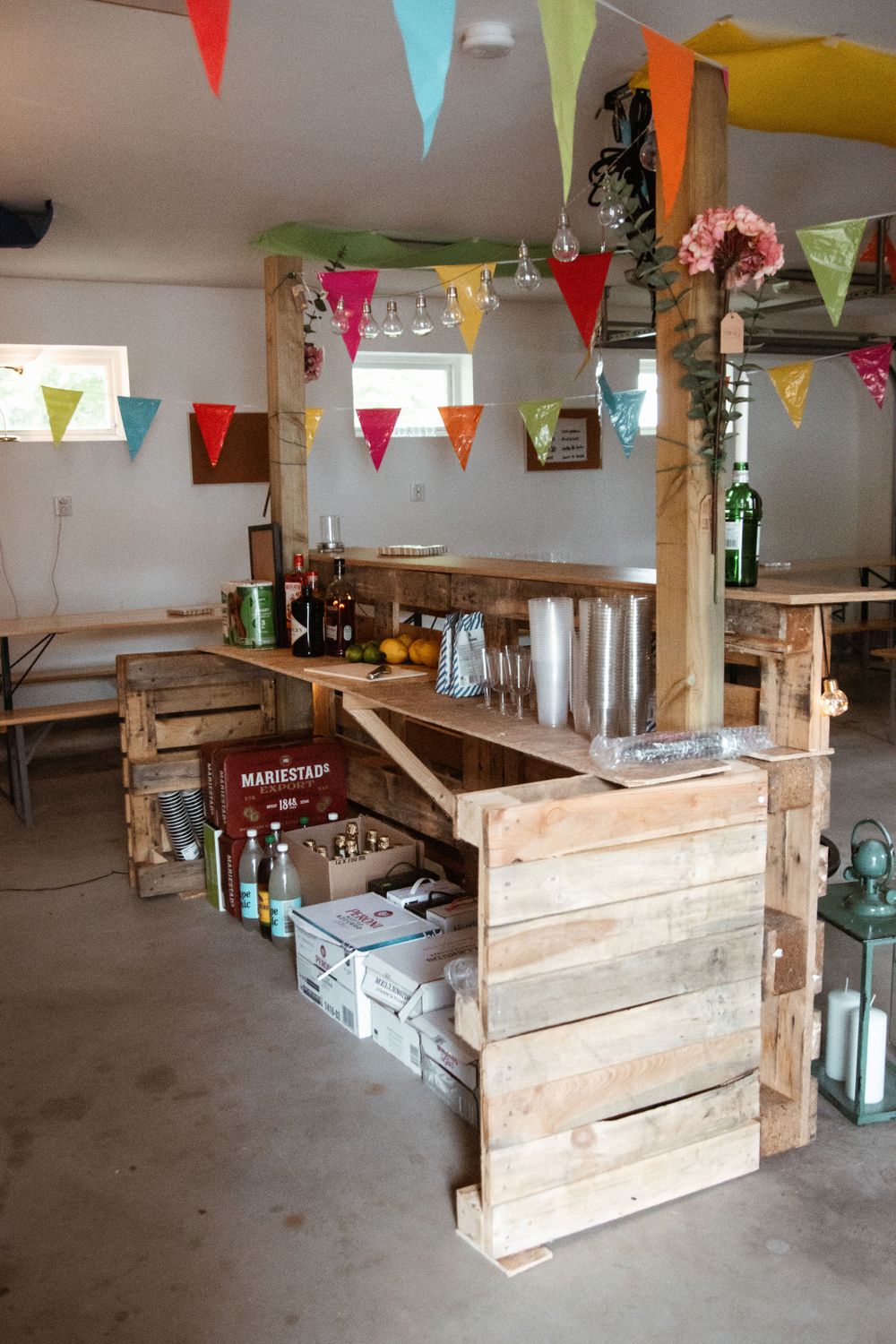 Rustic wooden bar setup with colorful bunting flags decorating the ceiling.