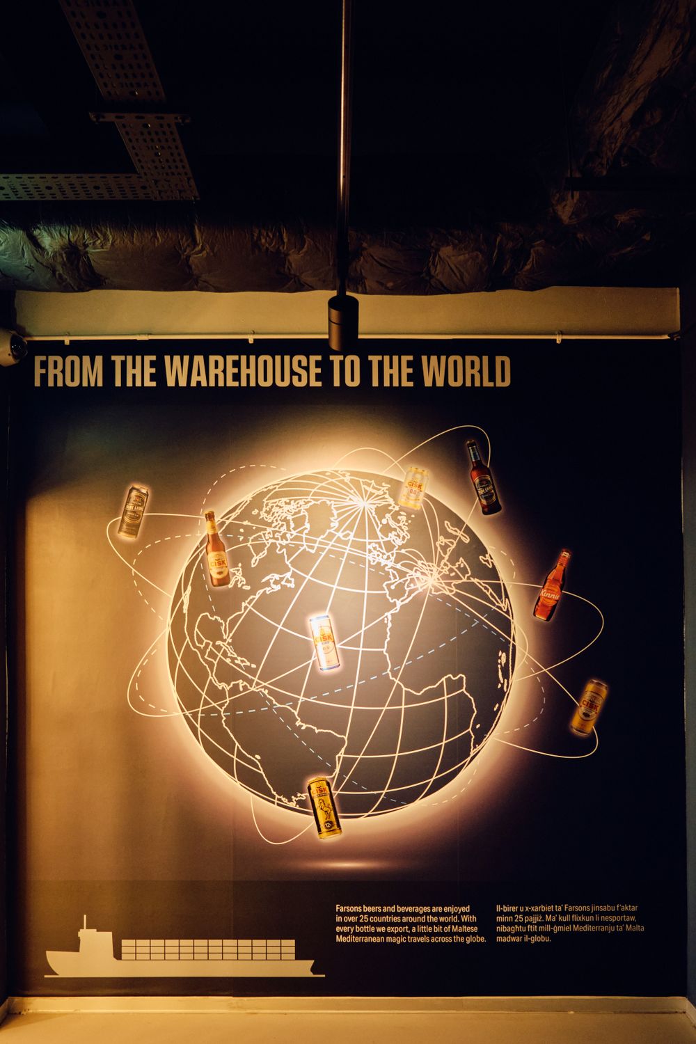 Illuminated museum display showing global beer distribution with glowing world map and bottle graphics.
