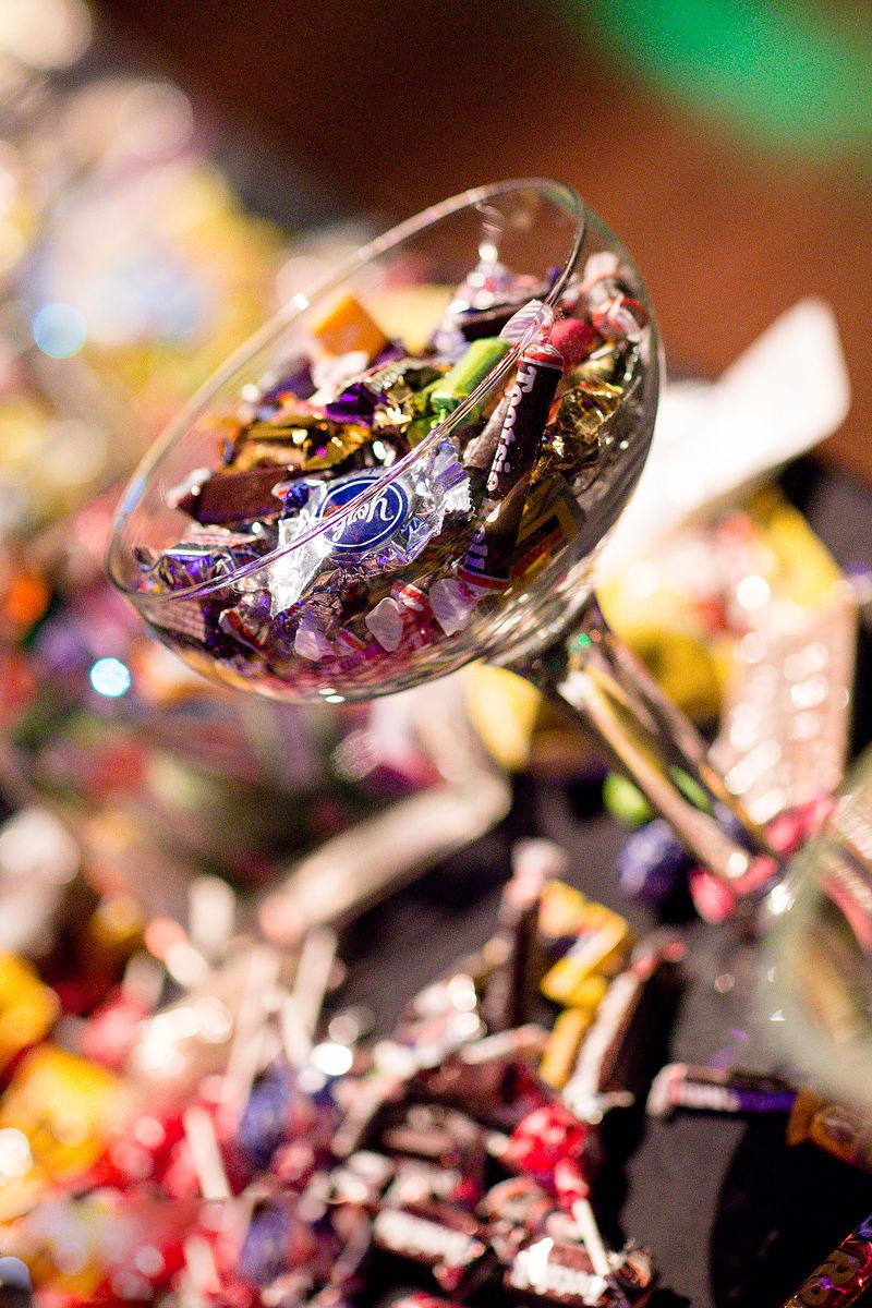 Martini glass filled with colorful wrapped candies and chocolates for party decoration.