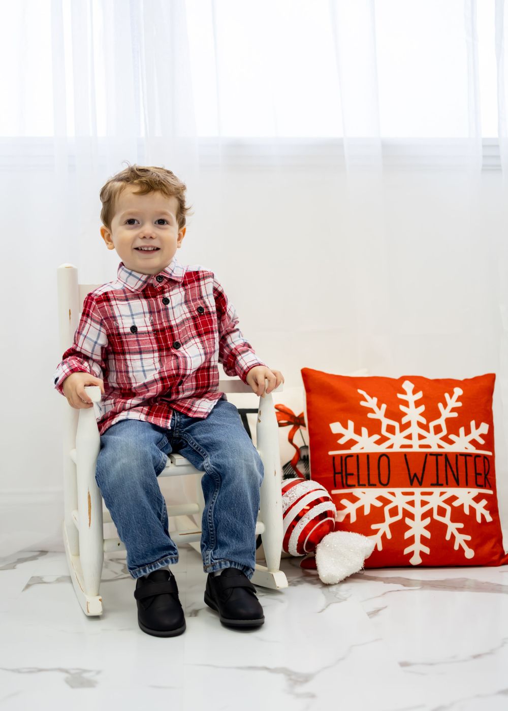 little boy sitting on rocking chair for christmas photo