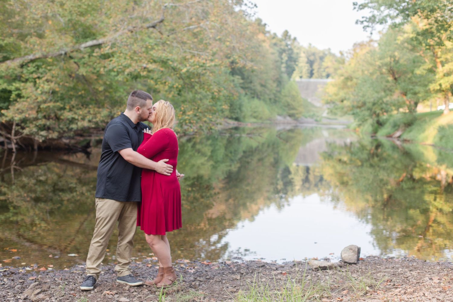 A romantic riverside photoshoot with reflective water and natural scenery.