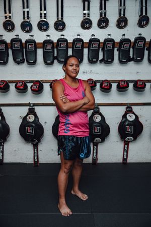 Boxing gloves and equipment line the wall of a martial arts training facility.