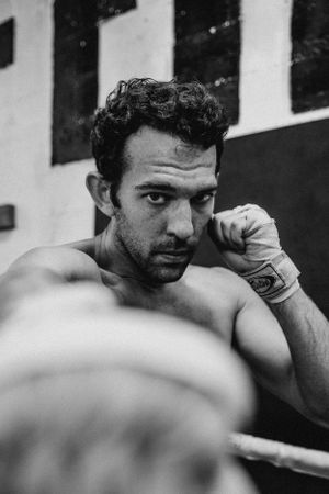 Black and white close-up of boxing defensive stance during training.
