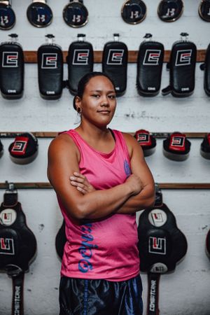 Training gear and protective equipment displayed on a white wall in a boxing gym.