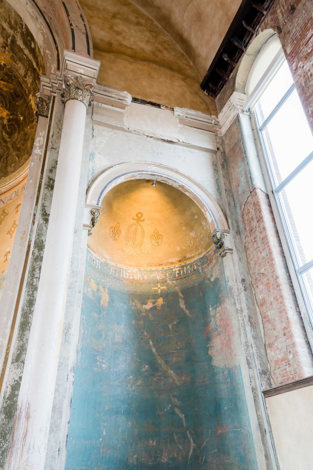 Historic church interior featuring ornate architectural details with arched alcove and decorative columns.