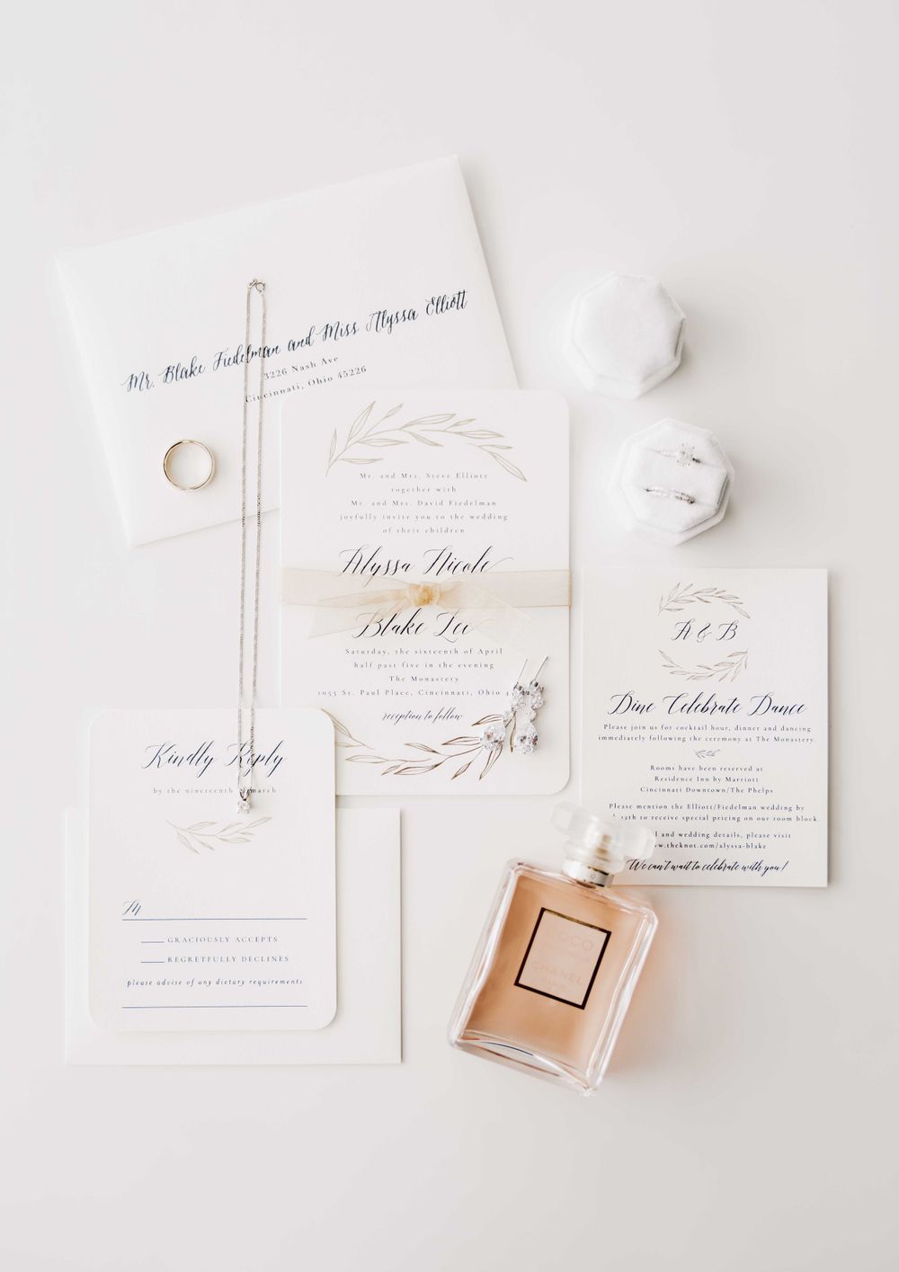 Elegant wedding invitation suite in white with perfume bottle and minimalist design.