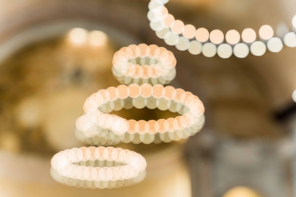 Close-up of circular pearl-like chandeliers creating elegant lighting effect in ballroom.