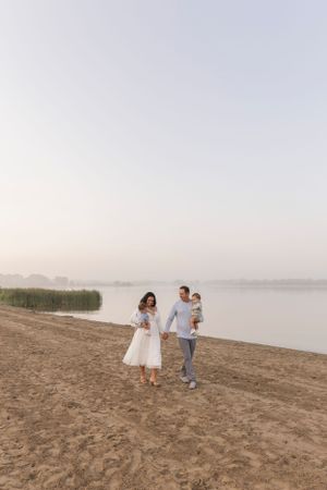 family of four walking together on the beach at stony creek metropark