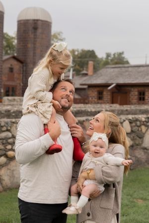 family of four playing with a dad giving his daughter a shoulder ride