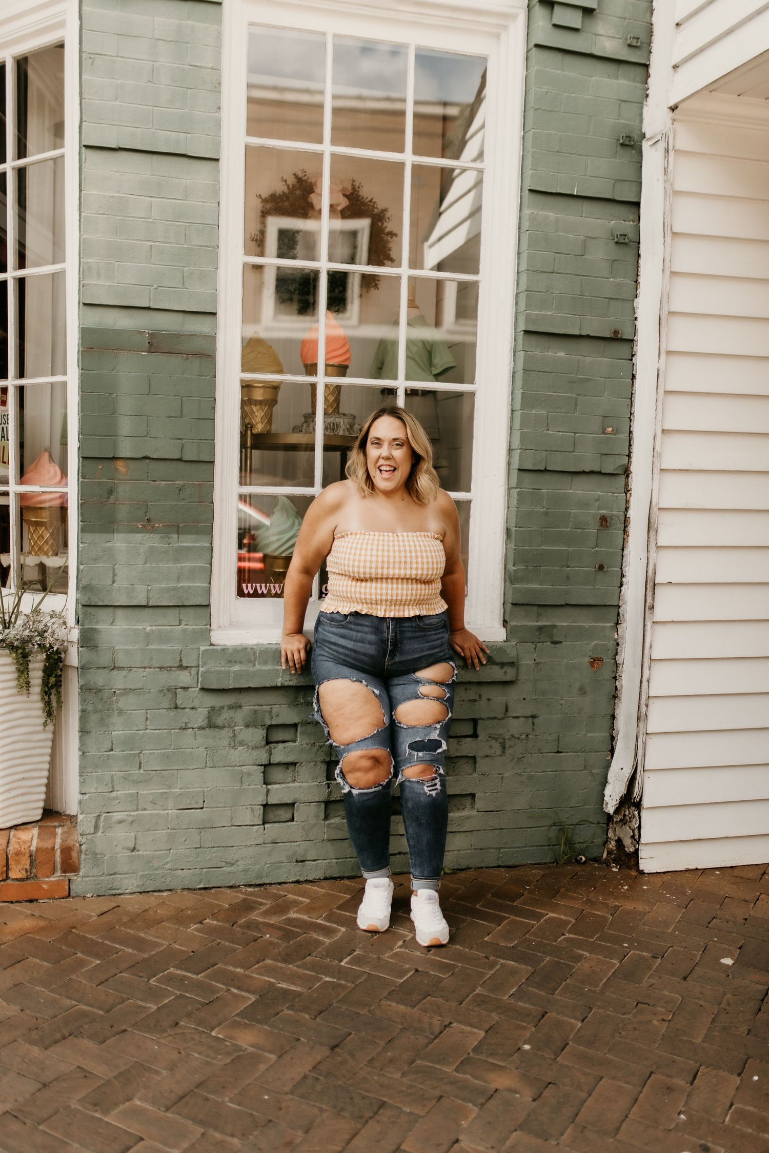 Lifestyle portraits against a white building with green shutters and brick pathway.